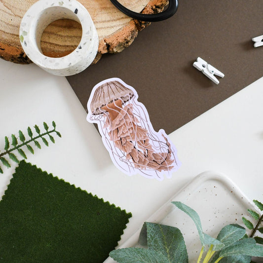 Decorative sticker of a jellyfish on a surface with plants and a wooden block.