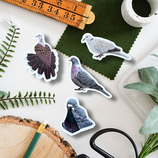 Set of bird stickers of doves and pigeons on a surface with a ruler, scissors, and natural elements.