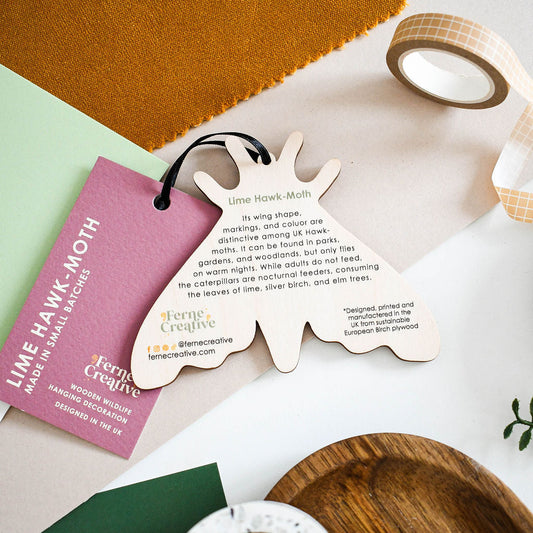 Lime hawk moth wooden decoration back with facts printed on. With pink branded swing tag
