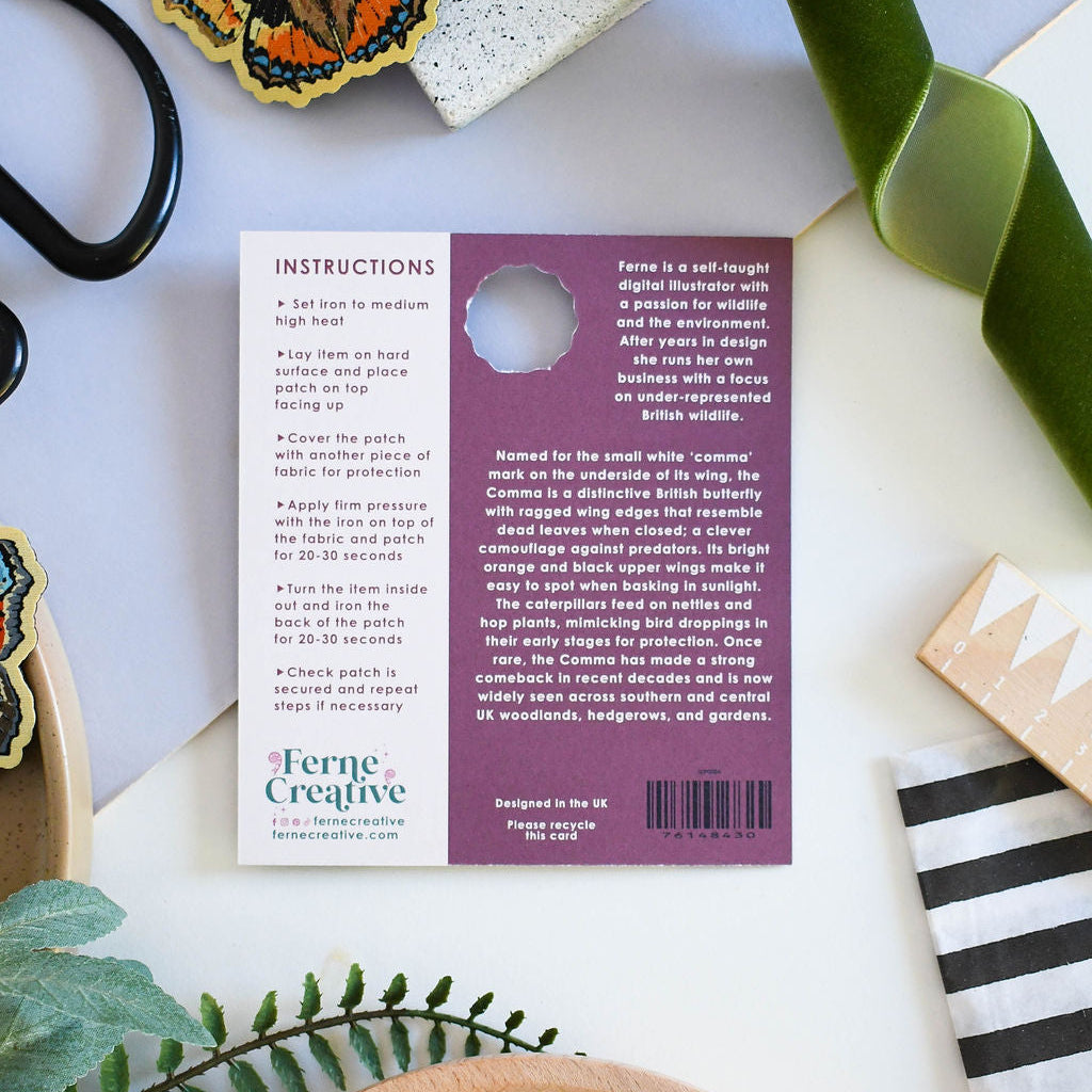 Back of a product packaging with text and a butterfly design, surrounded by craft materials.