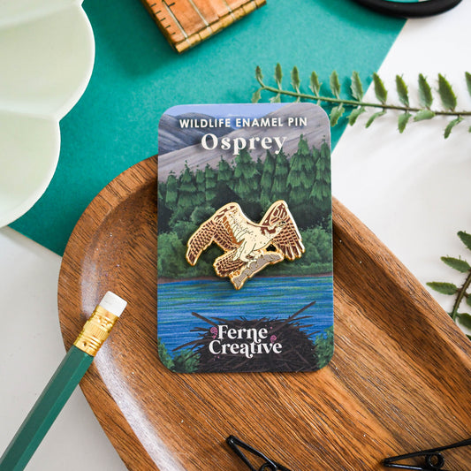 Osprey enamel pin on a card with 'Ferne Creative' branding, placed on a wooden tray.