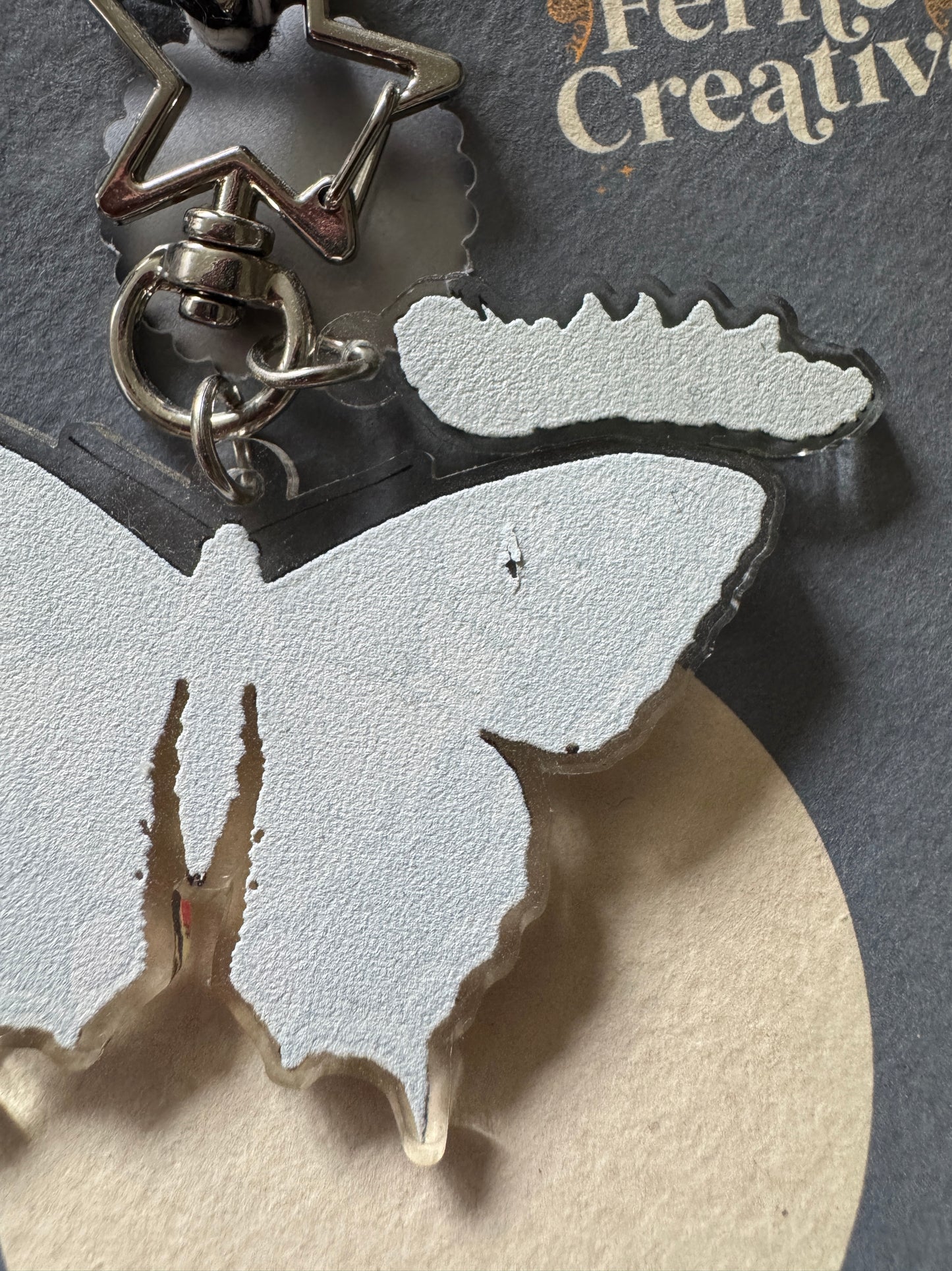 Schlüsselanhänger aus recyceltem Kunststoff mit Schwalbenschwanz-Schmetterling und Raupe
