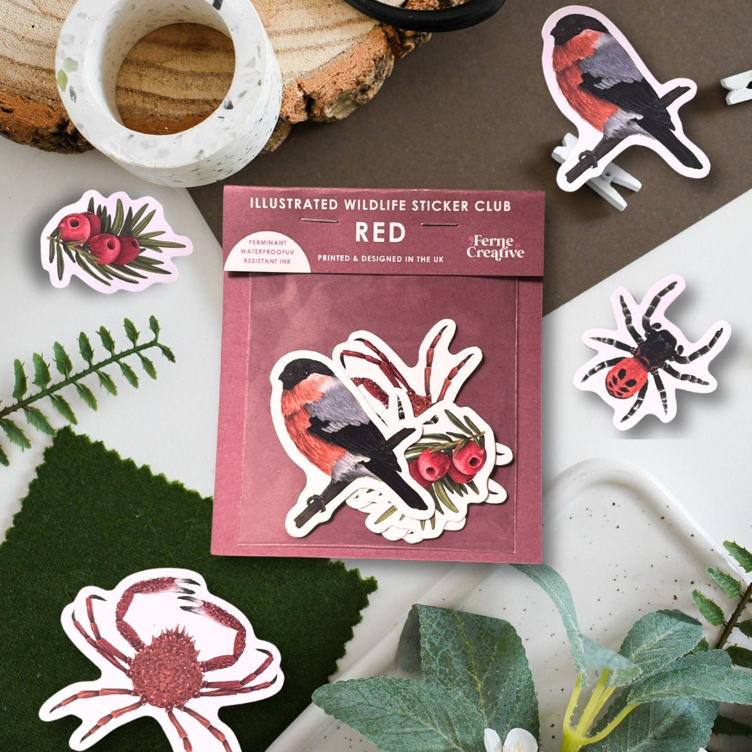 Illustrated wildlife stickers with a pack labeled 'Red' on a natural background.