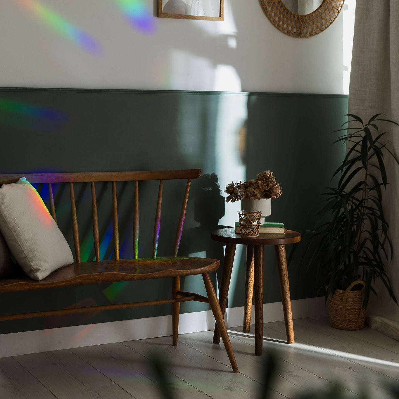 Nest living room with wooden bench, small table, and plant against a green wall.