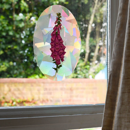 Stained glass suncatcher with pink foxglove design on a window