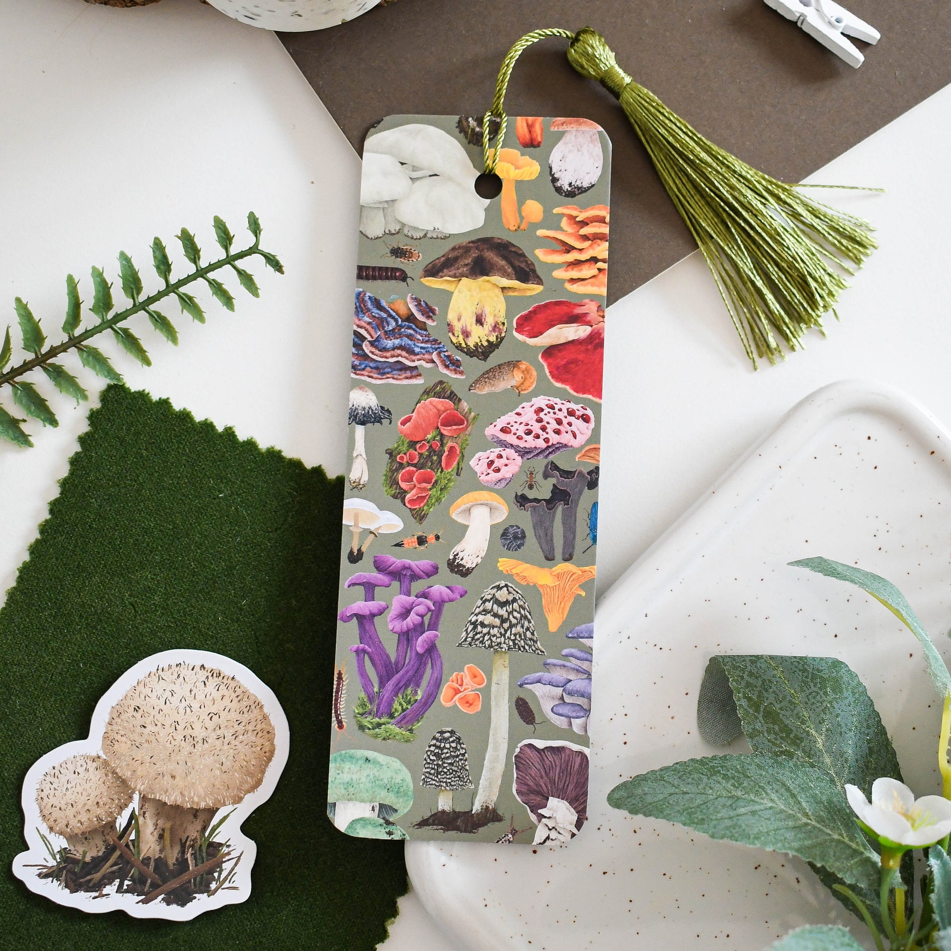 Boomark with mushroom design on a surface with greenery