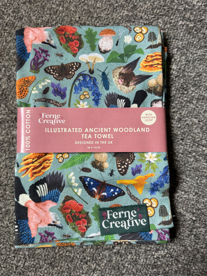 Ferne Creative tea towel with nature-themed design on a gray surface