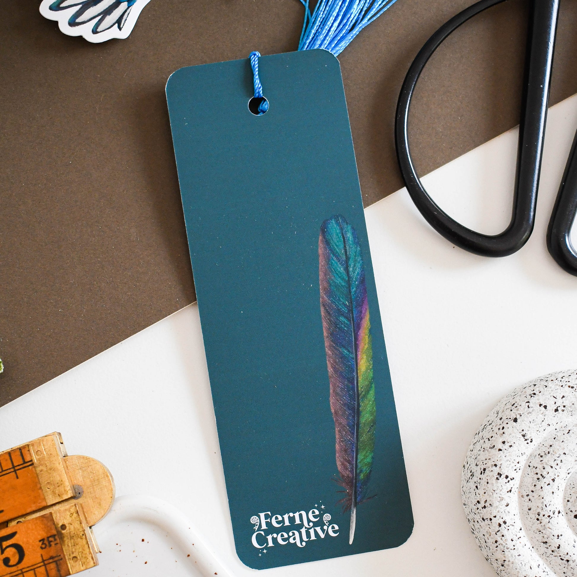 Bookmark with feather design on a table with stationery items